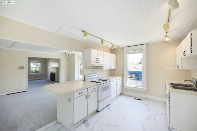 kitchen featuring plenty of natural light, electric stove, and white cabinets