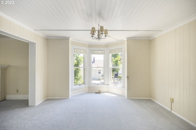 carpeted empty room featuring wooden ceiling, a notable chandelier, and crown molding