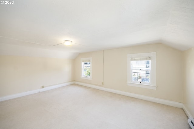 bonus room with light colored carpet and vaulted ceiling