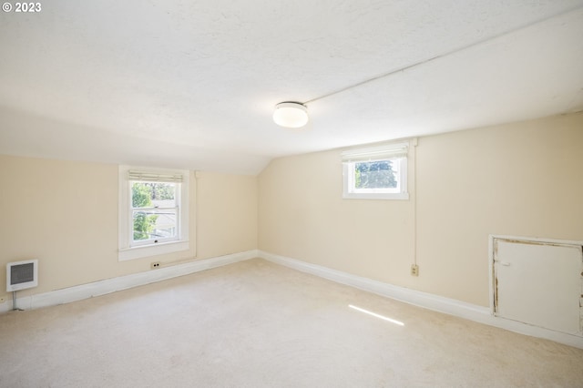 spare room with lofted ceiling and light colored carpet