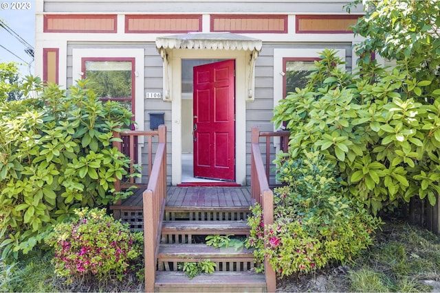 view of exterior entry featuring a wooden deck