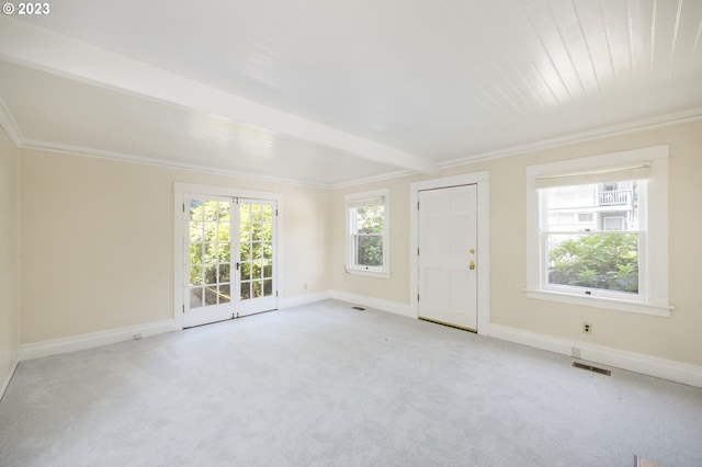 spare room featuring ornamental molding, light carpet, and beamed ceiling