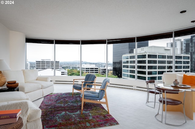 carpeted living room featuring a textured ceiling, a baseboard heating unit, and expansive windows