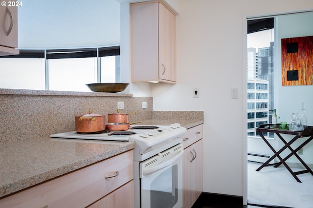 kitchen with light brown cabinets, tasteful backsplash, and electric range