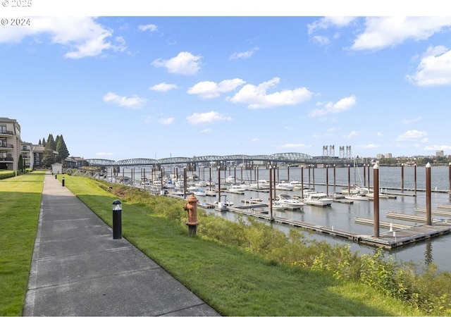 view of dock featuring a lawn and a water view