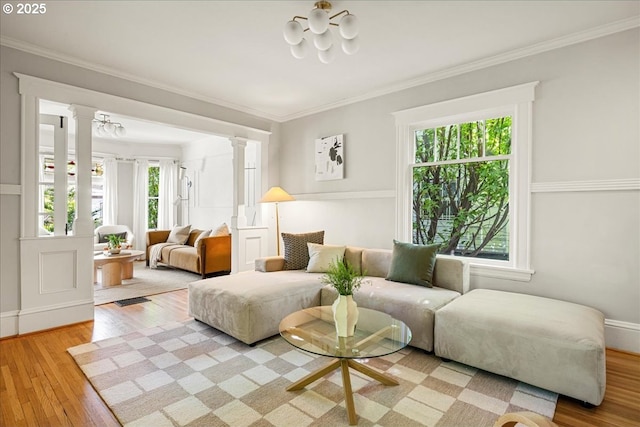interior space featuring ornate columns, a healthy amount of sunlight, and light wood finished floors
