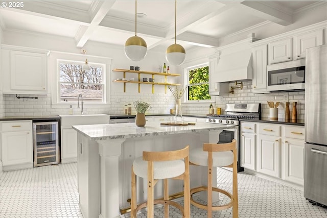 kitchen featuring a sink, beverage cooler, stainless steel appliances, custom range hood, and coffered ceiling