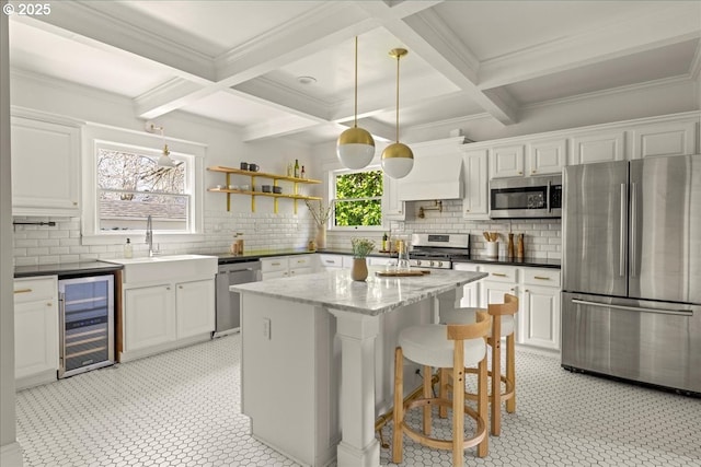 kitchen with beverage cooler, backsplash, beam ceiling, and stainless steel appliances