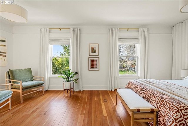 bedroom with baseboards, light wood-style flooring, and visible vents