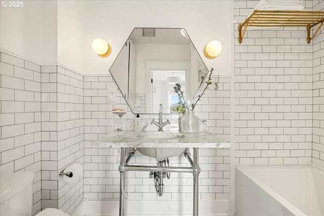 bathroom featuring tile walls and toilet