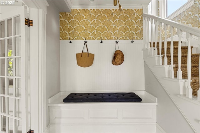 mudroom with crown molding, wallpapered walls, and a healthy amount of sunlight
