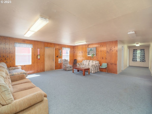 carpeted living room featuring wooden walls