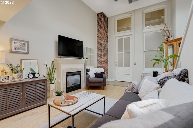 living room with brick wall, high vaulted ceiling, and light wood-type flooring