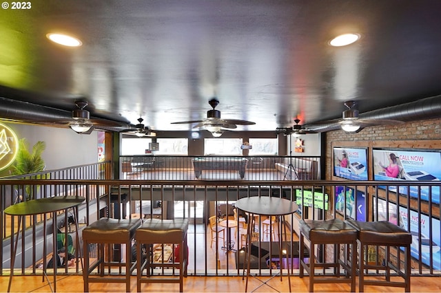 interior space featuring brick wall and ceiling fan