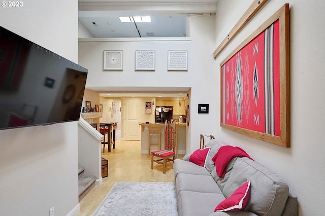 living room with light wood-type flooring and high vaulted ceiling