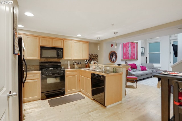 kitchen with pendant lighting, light brown cabinets, light hardwood / wood-style floors, black appliances, and sink