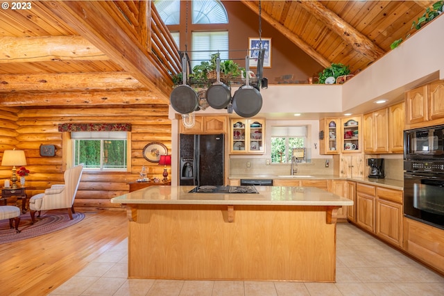 kitchen featuring a wealth of natural light, a center island, and black appliances