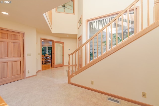 carpeted entrance foyer featuring ceiling fan