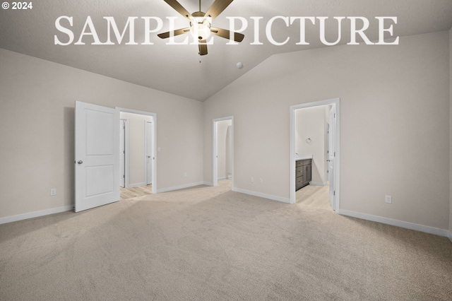 unfurnished bedroom featuring light carpet, ensuite bath, ceiling fan, and lofted ceiling