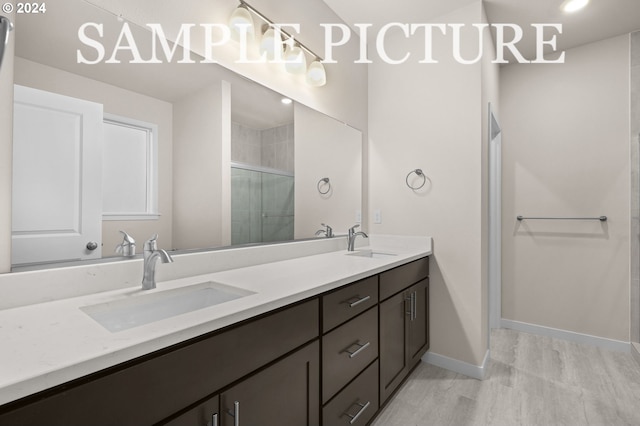 bathroom with vanity, a shower with shower door, and hardwood / wood-style flooring