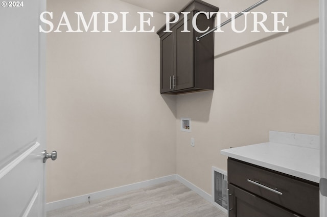 laundry room featuring cabinets, hookup for a washing machine, and light hardwood / wood-style flooring