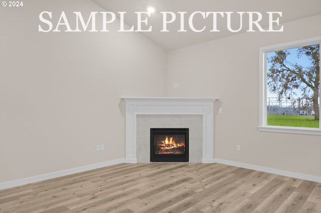 room details featuring wood-type flooring and a tile fireplace