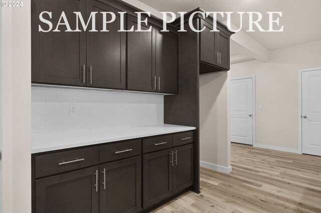 kitchen with dark brown cabinetry and light hardwood / wood-style floors