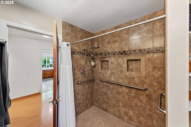 bathroom featuring wood finished floors and a shower stall