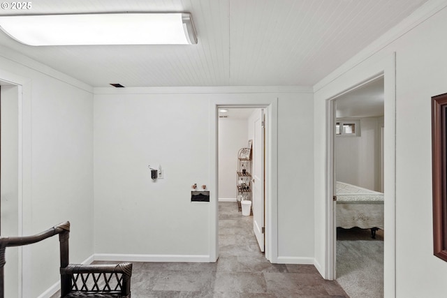 hall featuring crown molding and baseboards