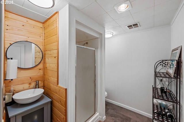 bathroom with visible vents, a stall shower, wood walls, vanity, and toilet