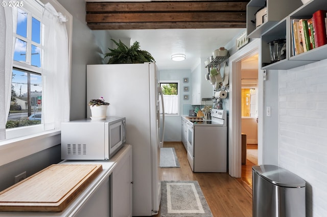 kitchen with white appliances, light hardwood / wood-style flooring, and beamed ceiling