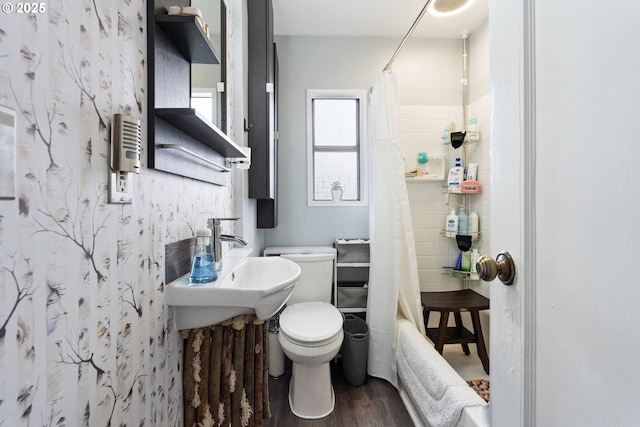 bathroom with shower / tub combo with curtain, wood-type flooring, and toilet