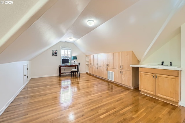 17472 NW Gilbert Ln, Portland, OR 97229 - bonus room with light wood finished floors, lofted ceiling, baseboards, a textured ceiling, and an office area