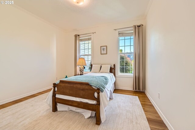 17472 NW Gilbert Ln, Portland, OR 97229 - bedroom featuring wood finished floors, baseboards, and crown molding