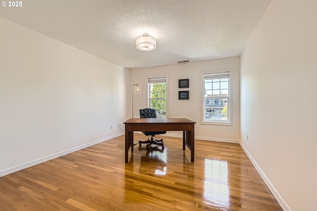 17472 NW Gilbert Ln, Portland, OR 97229 - office area featuring light wood-type flooring, a textured ceiling, and baseboards