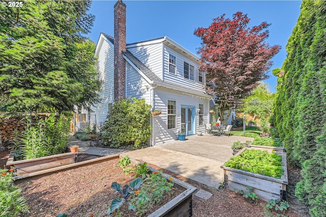 17472 NW Gilbert Ln, Portland, OR 97229 - rear view of property with a garden, a chimney, a patio area, and french doors