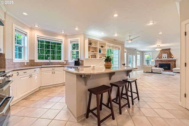 17472 NW Gilbert Ln, Portland, OR 97229 - kitchen with a sink, appliances with stainless steel finishes, crown molding, recessed lighting, and light tile patterned flooring