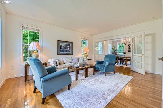 17472 NW Gilbert Ln, Portland, OR 97229 - living room featuring a chandelier, light wood-style flooring, and plenty of natural light