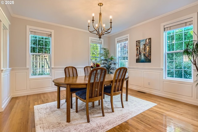 17472 NW Gilbert Ln, Portland, OR 97229 - dining room featuring light wood-style flooring, a decorative wall, plenty of natural light, a chandelier, and crown molding