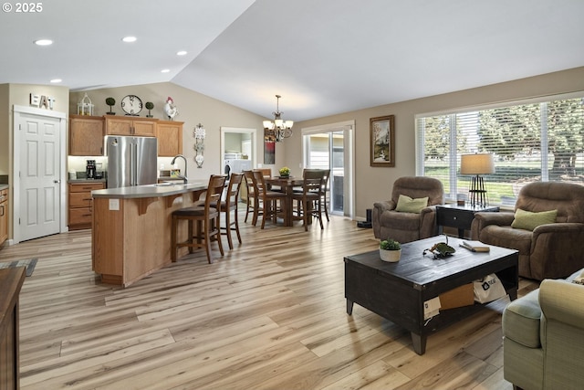 2057 SE Blue Skies Ln, Prineville, OR 97754 - living room featuring vaulted ceiling, a chandelier, light wood-type flooring, and recessed lighting