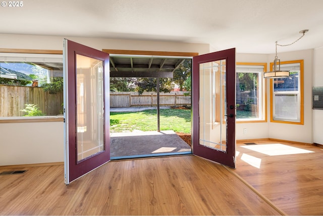 doorway featuring wood finished floors, baseboards, and french doors