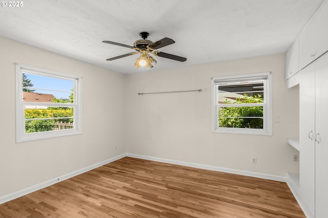 6105 NE 18th Ave, Portland, OR 97211 - unfurnished bedroom featuring light wood-style flooring, ceiling fan, and a textured ceiling
