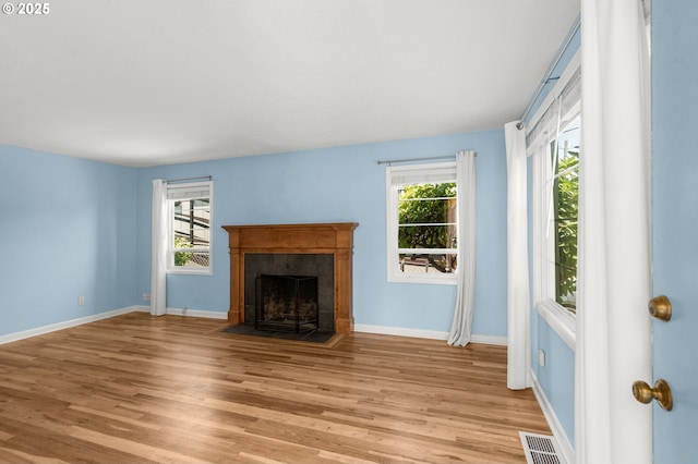 6105 NE 18th Ave, Portland, OR 97211 - unfurnished living room with healthy amount of natural light, light wood-type flooring, and a tiled fireplace
