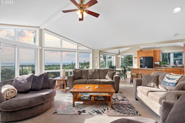 carpeted living room with high vaulted ceiling, ceiling fan, and beamed ceiling