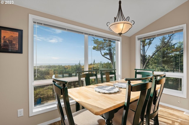 dining area with light hardwood / wood-style floors and vaulted ceiling