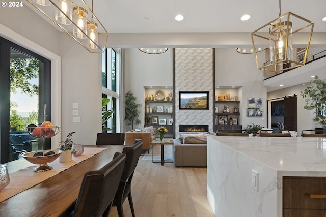 dining space with a healthy amount of sunlight, light wood-type flooring, and a large fireplace