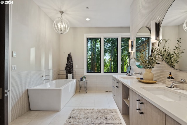 bathroom featuring vanity, a bath, a notable chandelier, and tile patterned flooring