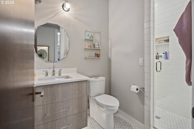 bathroom with tile patterned floors, toilet, vanity, and walk in shower