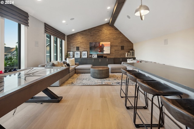 interior space featuring beam ceiling, high vaulted ceiling, and light hardwood / wood-style flooring