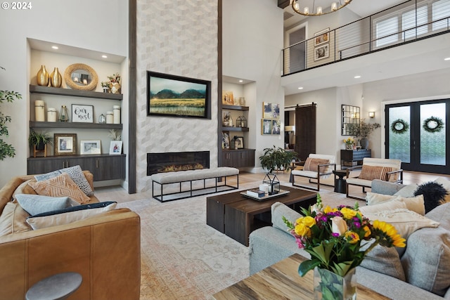 living room with a healthy amount of sunlight, a barn door, and a towering ceiling